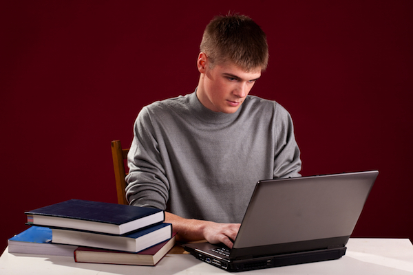 A teenage boy studies using the ZAPS online SAT-Practice Test.
